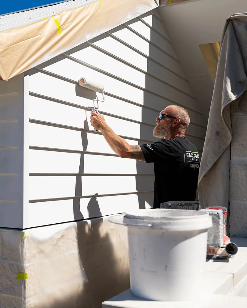 Jeff professionally painting the exterior of a house