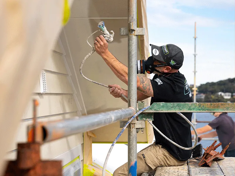 Jeff professionally spray painting a houses exterior